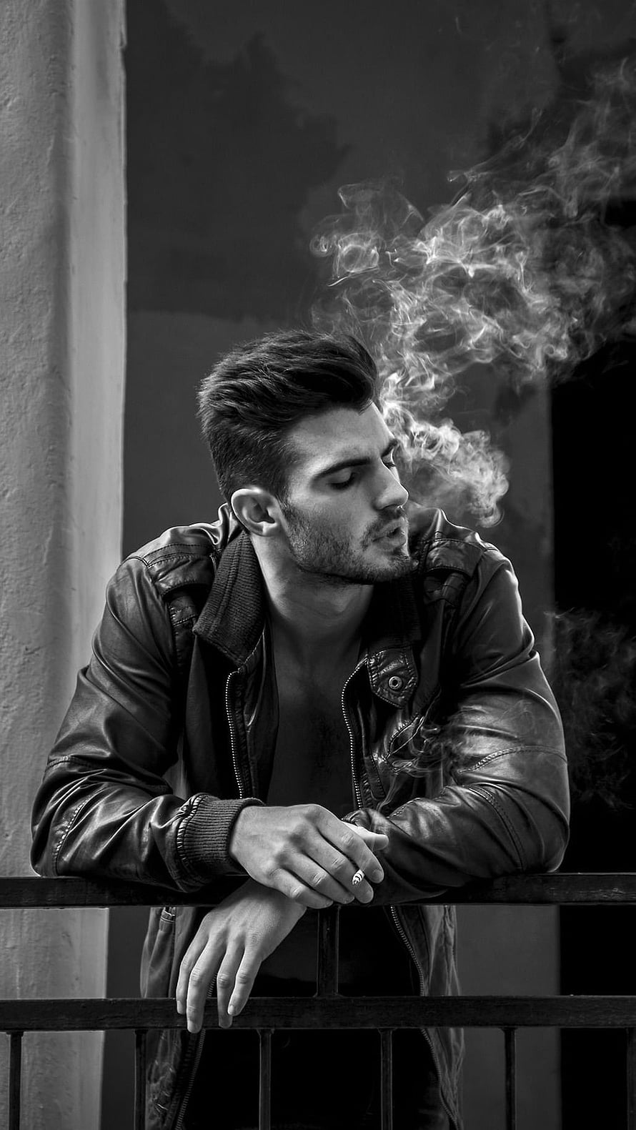 Moody Black and White Portrait of a Man in a Leather Jacket Smoking on a Balcony HD phone wallpaper