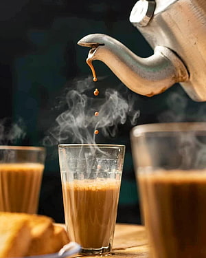 Steaming Chai Poured from a Traditional Indian Kettle into a Glass Cup HD phone wallpaper