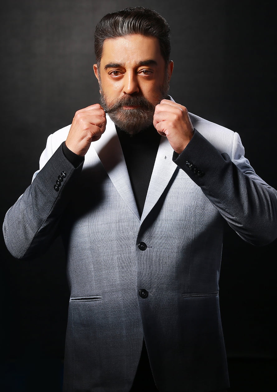 Kamal Haasan in a grey suit with a confident boxing stance against a dark studio background HD phone wallpaper
