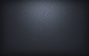 Dark Grey Textured Surface with Soft Central Light Gradient and Vignette HD wallpaper