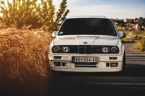 White BMW E30 325i Classic Sedan Parked on Countryside Road at Golden Hour HD wallpaper