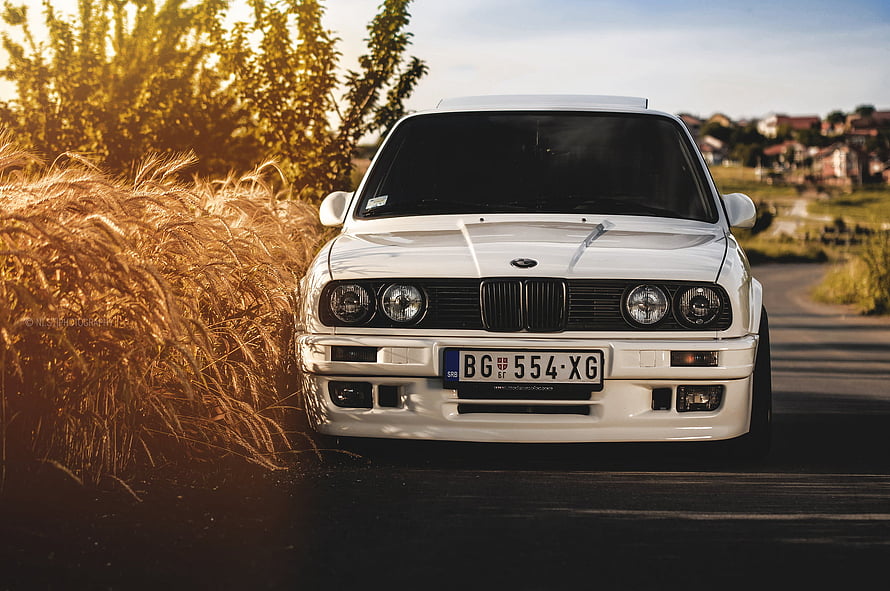 White BMW E30 325i Classic Sedan Parked on Countryside Road at Golden Hour HD wallpaper