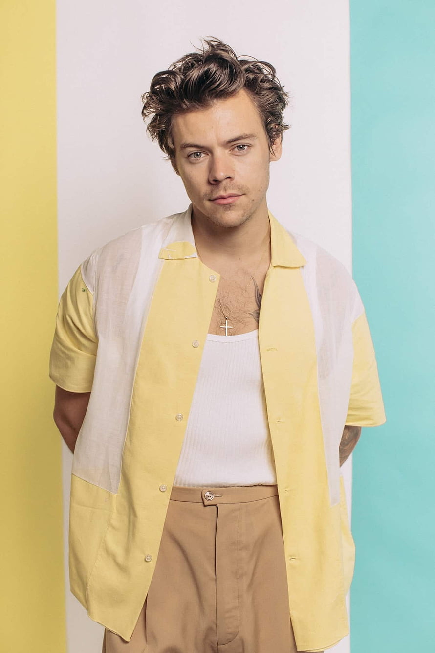 Harry Styles in a yellow shirt and white tank top against a pastel striped background HD phone wallpaper