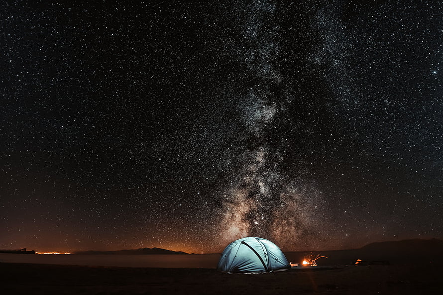 Illuminated Camping Tent Under the Milky Way Galaxy in a Dark Desert Landscape HD wallpaper