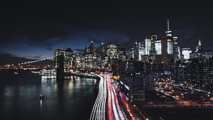New York City Skyline at Night with Brooklyn Bridge and Long Exposure Traffic Trails HD wallpaper
