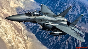 F-15 Eagle Fighter Jet Banking Over Mountainous Desert Terrain HD wallpaper