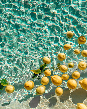 Fresh Lemons Floating in Turquoise Pool Water with Sunlight Caustics HD phone wallpaper