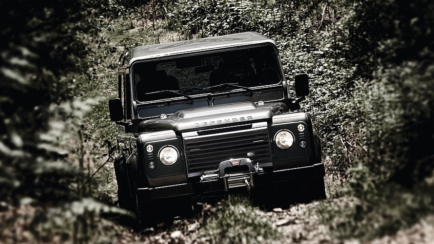 Black Land Rover Defender Off-Roading on a Forest Trail HD wallpaper