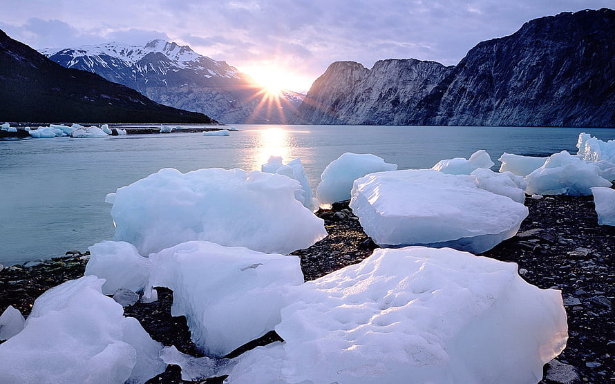 Glacial Icebergs on a Rocky Shore with Snow-Capped Mountains at Sunset HD wallpaper