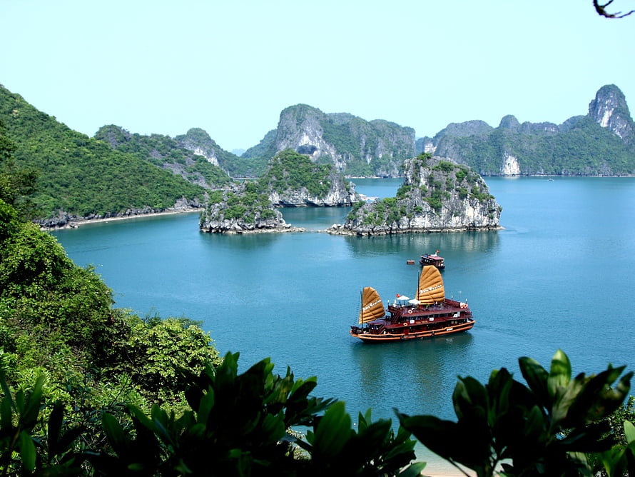 Traditional Junk Boat Sailing Through Limestone Karst Islands in Ha Long Bay HD wallpaper