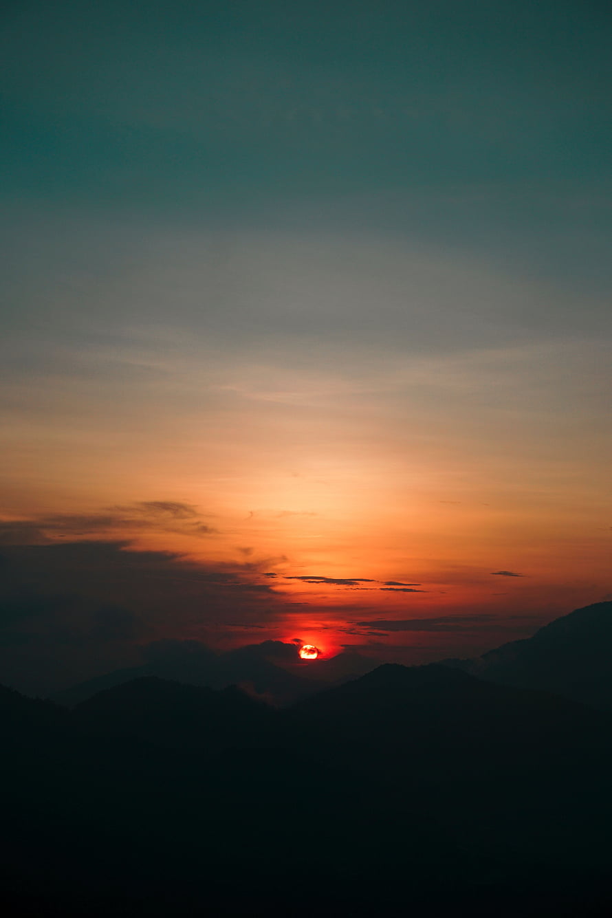 Dramatic Mountain Sunset with Fiery Sun and Layered Clouds HD phone wallpaper