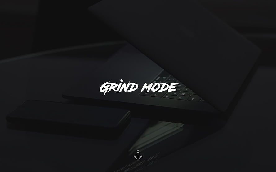 Dark Minimalist Desk Setup With Laptop And Smartphone Featuring Grind Mode Typography HD wallpaper