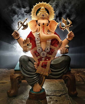 Ganesha seated on ornate throne holding trident and axe with radiant golden halo and dramatic smoke background HD phone wallpaper