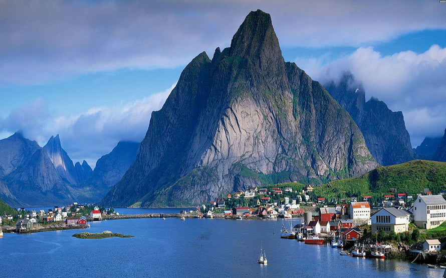Dramatic fjord landscape with steep rocky peaks and a coastal village HD wallpaper