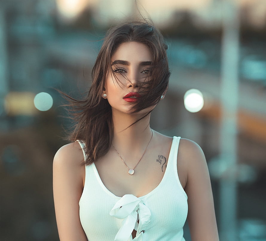 Portrait of a woman with windblown hair wearing a white top and red lipstick HD wallpaper