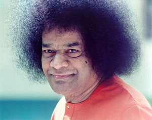 Sri Sathya Sai Baba Portrait in Orange Attire with Distinctive Hair HD wallpaper