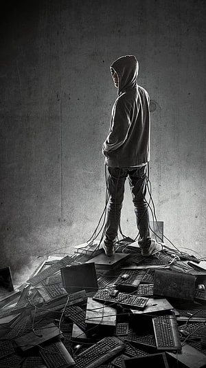 Hacker Standing on Pile of Keyboards and Laptops in Dark Room HD phone wallpaper
