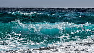 Turquoise Ocean Waves Crashing on Rocky Shore with White Sea Foam HD wallpaper