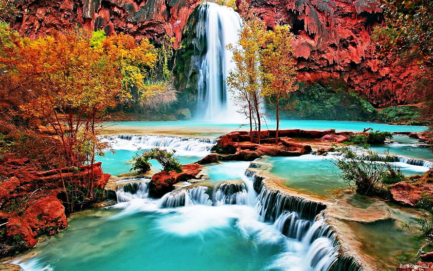 Vibrant Turquoise Waterfall Cascading Through Red Rock Canyon with Autumn Foliage HD wallpaper