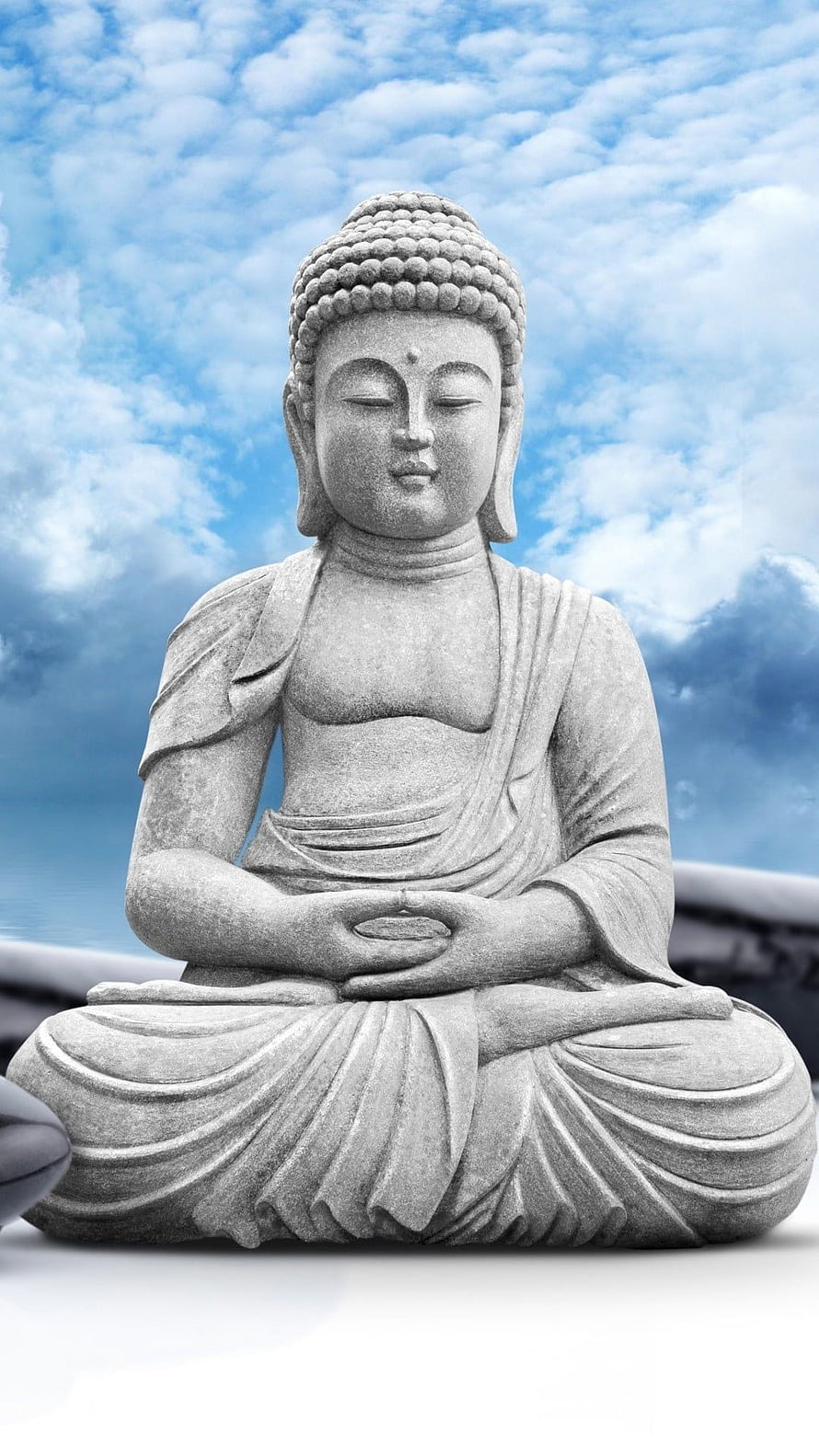 Serene Stone Buddha Statue in Meditation Pose Against a Blue Cloudy Sky HD phone wallpaper