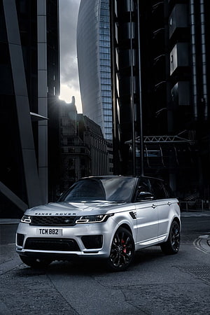 Silver Range Rover Sport HST parked on a city street with modern skyscrapers in the background HD phone wallpaper